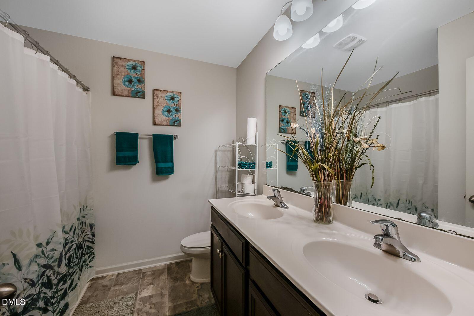 67 Prairie Street Clayton, NC 27527 - Photo 12 of 20 a bathroom with a sink a toilet and mirror