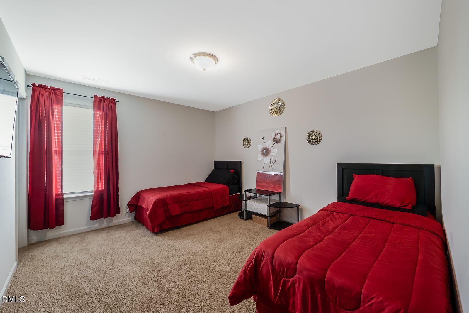 67 Prairie Street Clayton, NC 27527 - Photo 13 of 20 a bedroom with two beds and a chandelier
