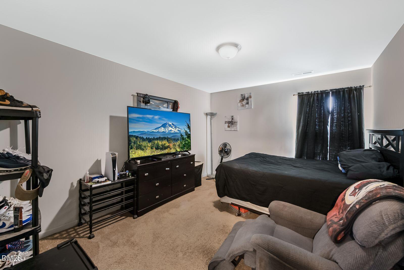 67 Prairie Street Clayton, NC 27527 - Photo 14 of 20 a bedroom with furniture and a flat screen tv