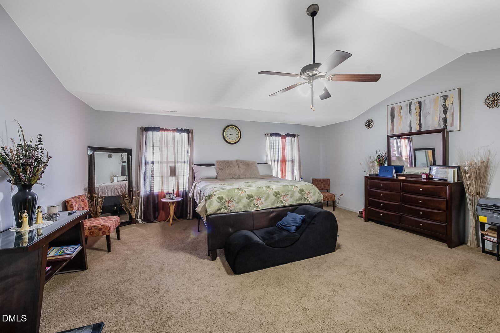 67 Prairie Street Clayton, NC 27527 - Photo 18 of 20 a spacious bedroom with a bed and a chandelier