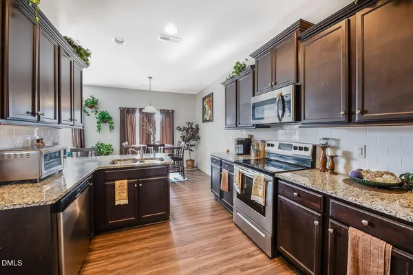 a kitchen with stainless steel appliances granite countertop a stove a sink dishwasher and a refrigerator