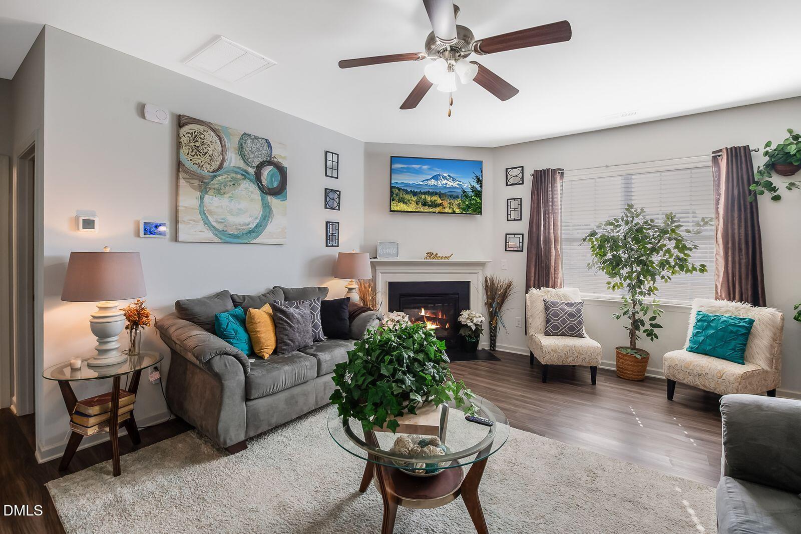 67 Prairie Street Clayton, NC 27527 - Photo 9 of 20 a living room with furniture a fireplace and a large mirror
