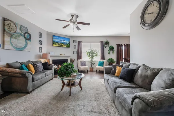 a living room with furniture a clock on wall and a window