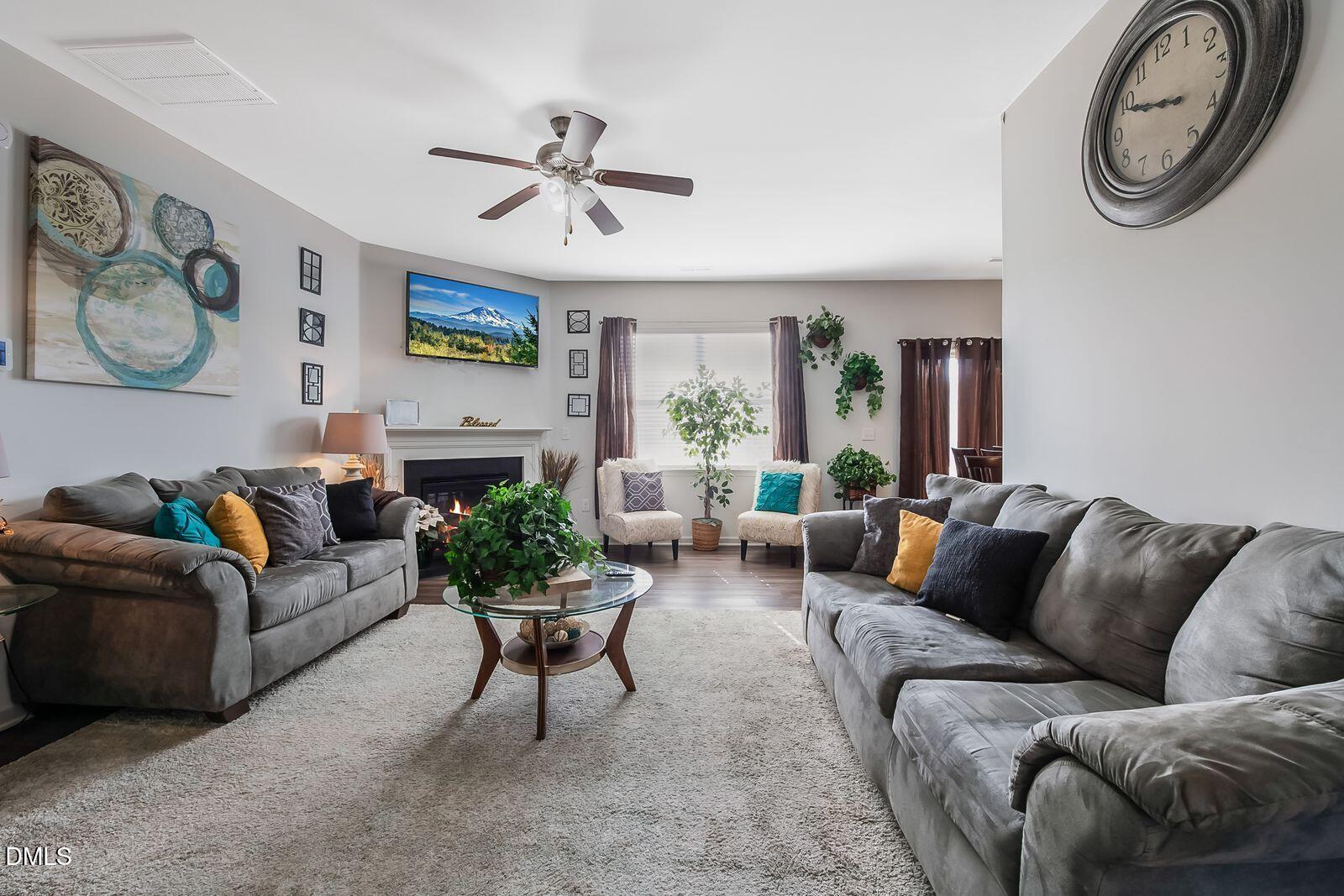 67 Prairie Street Clayton, NC 27527 - Photo 10 of 20 a living room with furniture a clock on wall and a window