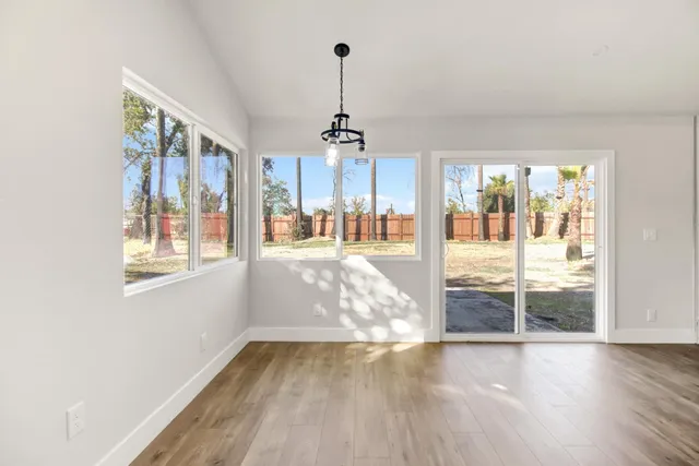 a view of empty room with wooden floor