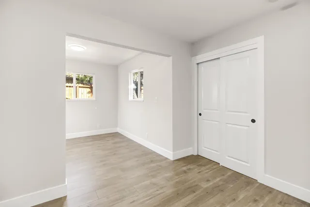 an empty room with windows and closet