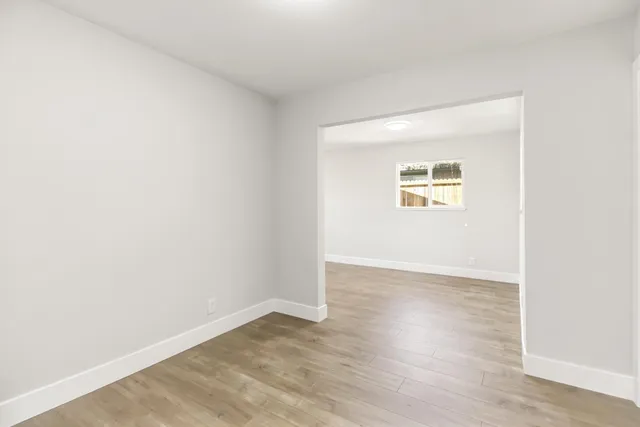 an empty room with wooden floor and a window