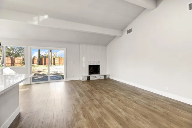 a view of empty room with wooden floor and fireplace