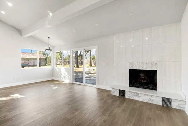 a view of a livingroom with wooden floor and a fireplace