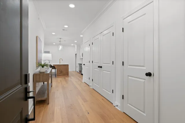 a view of a hallway with wooden floor table and chairs