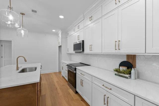 a kitchen with stainless steel appliances granite countertop a sink a stove and a refrigerator