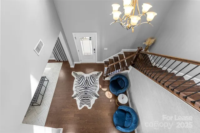 a view of a hallway with wooden floor and a rug