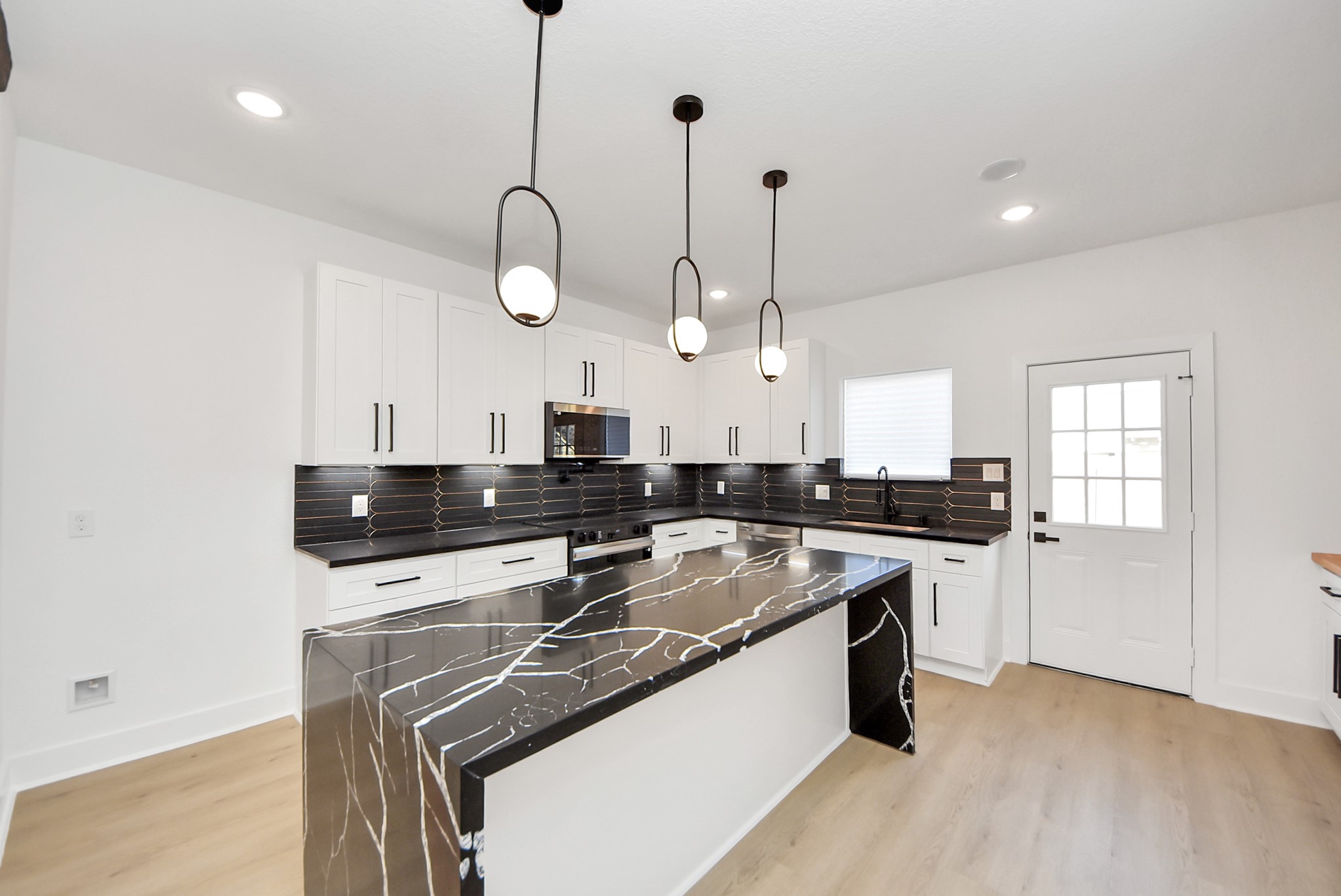 3319 Caplin Street Houston, TX 77026 - Photo 11 of 42 a kitchen with stainless steel appliances granite countertop a sink a stove and a wooden floors