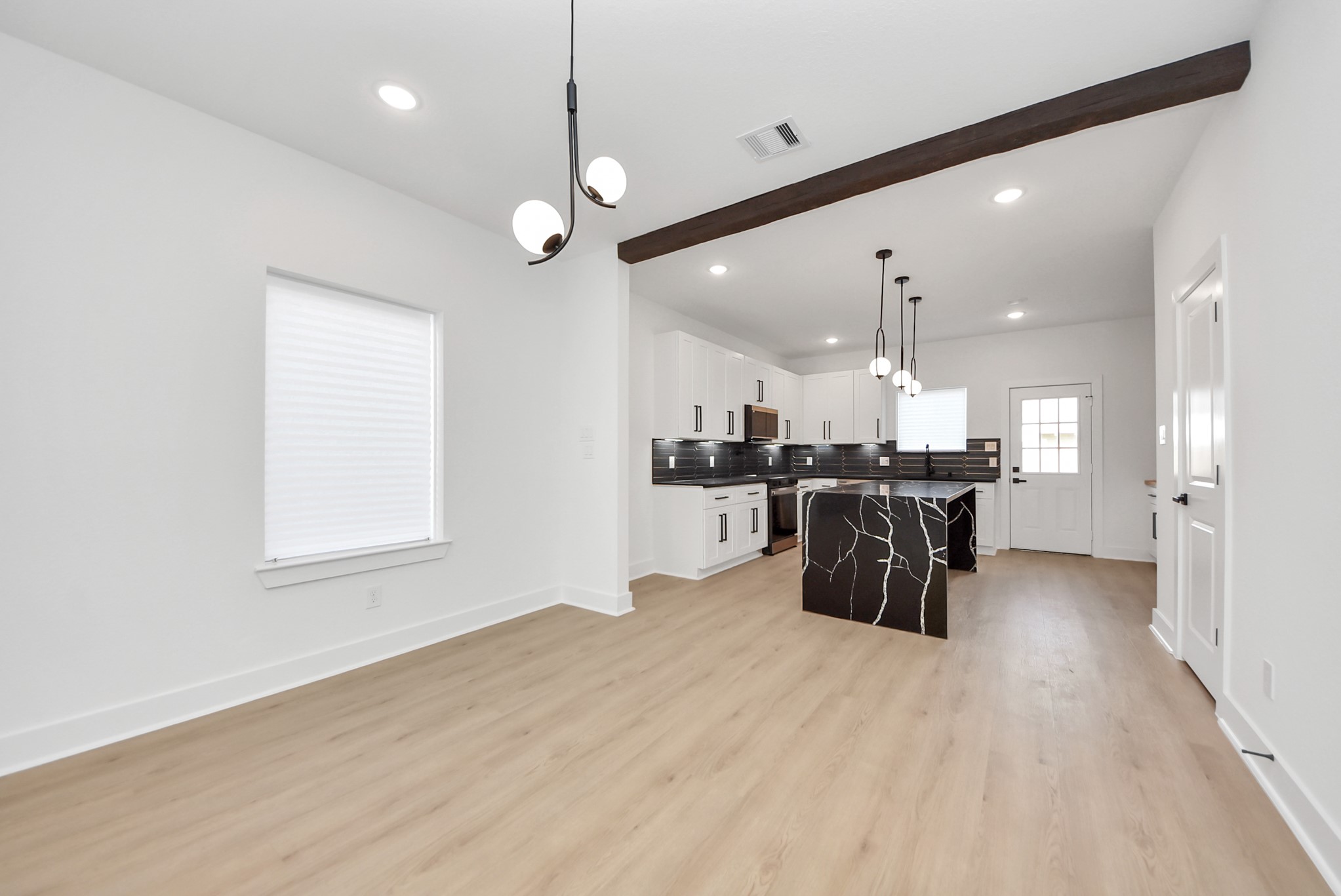 3319 Caplin Street Houston, TX 77026 - Photo 7 of 42 a kitchen with stainless steel appliances kitchen island granite countertop a refrigerator a oven a sink and a dining table with wooden floor