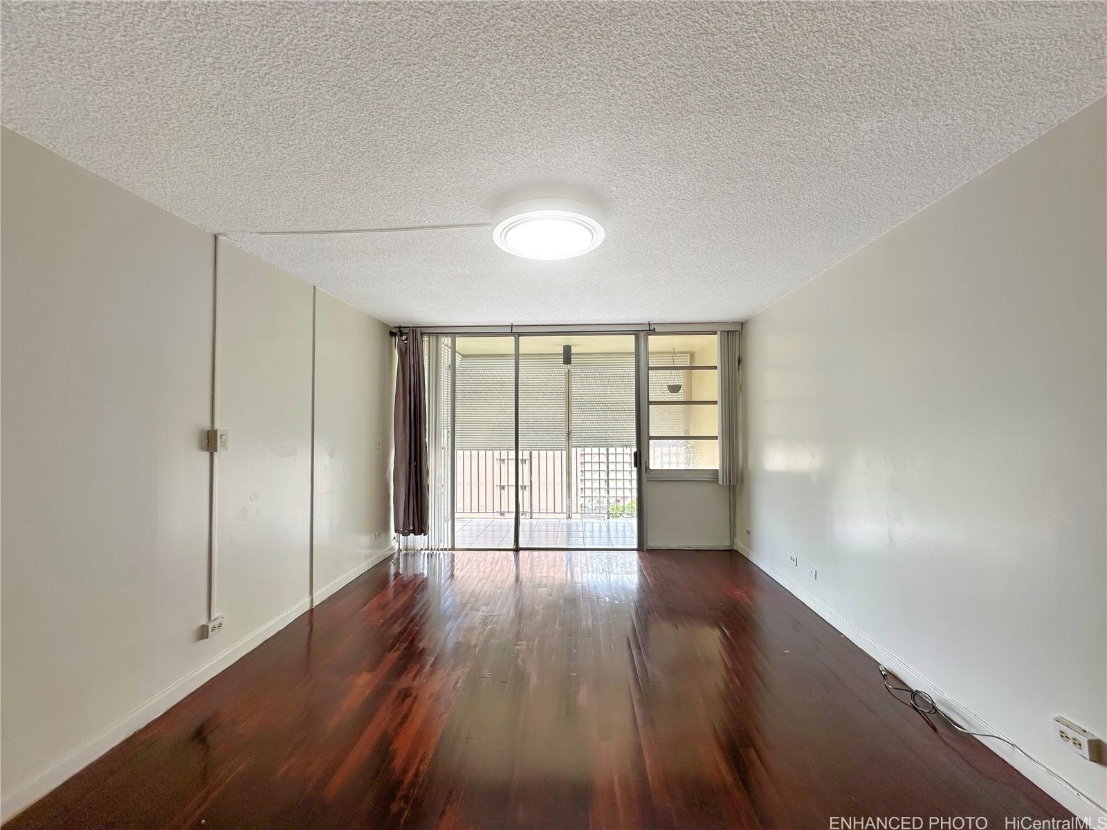 3161 Ala Ilima Street, Unit 903 Honolulu, HI 96818 - Photo 2 of 15 a view of an empty room with wooden floor and a window