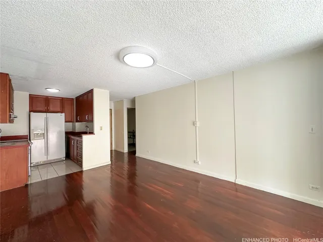 a view of a kitchen with a refrigerator and a stove top oven