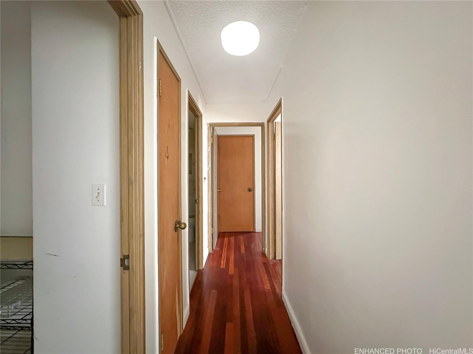 3161 Ala Ilima Street, Unit 903 Honolulu, HI 96818 - Photo 8 of 15 a view of a hallway with wooden floor