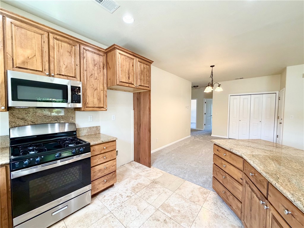 1037 Mark Twain Road Angels Camp, CA 95222 - Photo 19 of 52 a kitchen with stainless steel appliances granite countertop a stove and a microwave