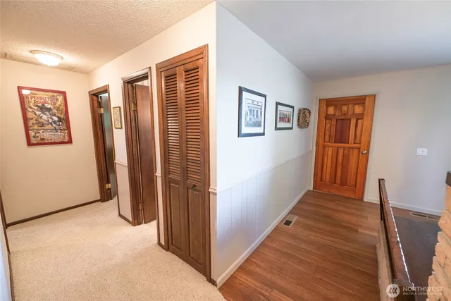 a view of a hallway with wooden floor and stairs