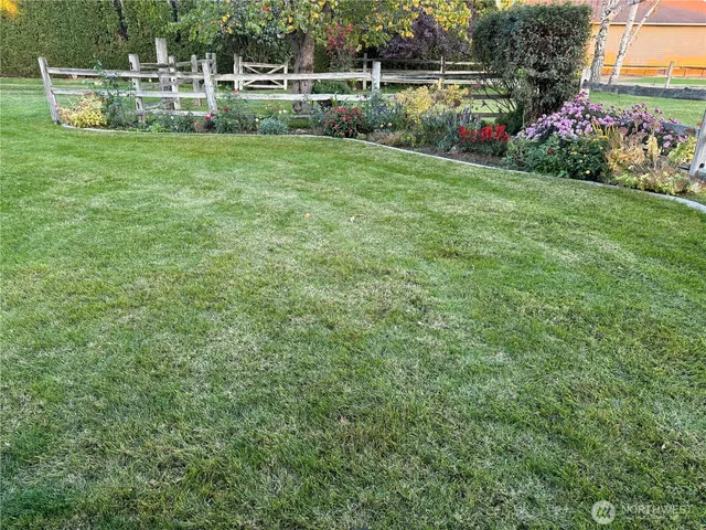 a view of a house with a big yard and potted plants