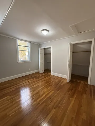 an empty room with wooden floor and closet