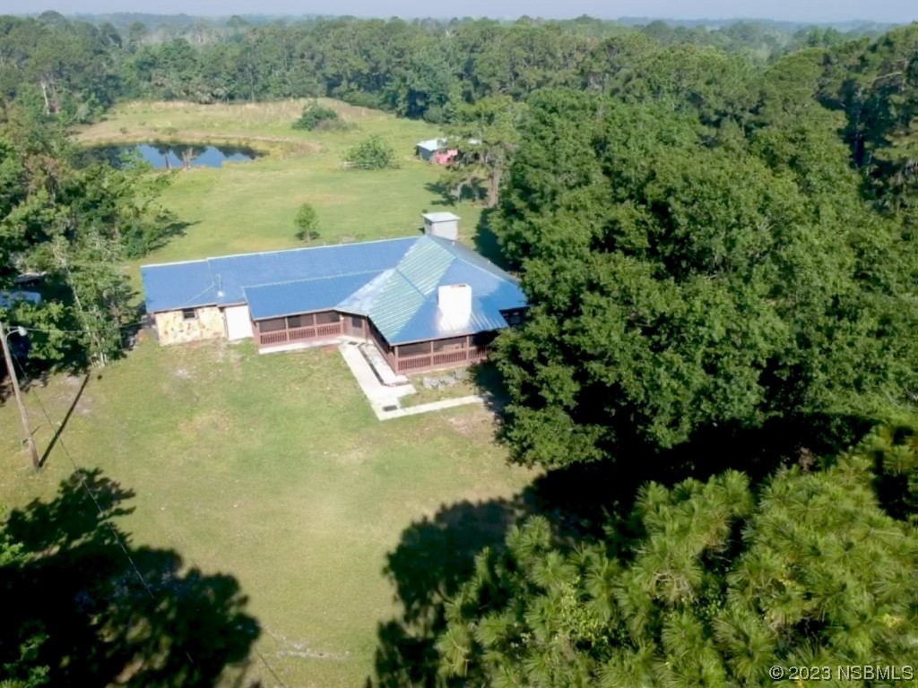 an aerial view of a house with a yard and lake view