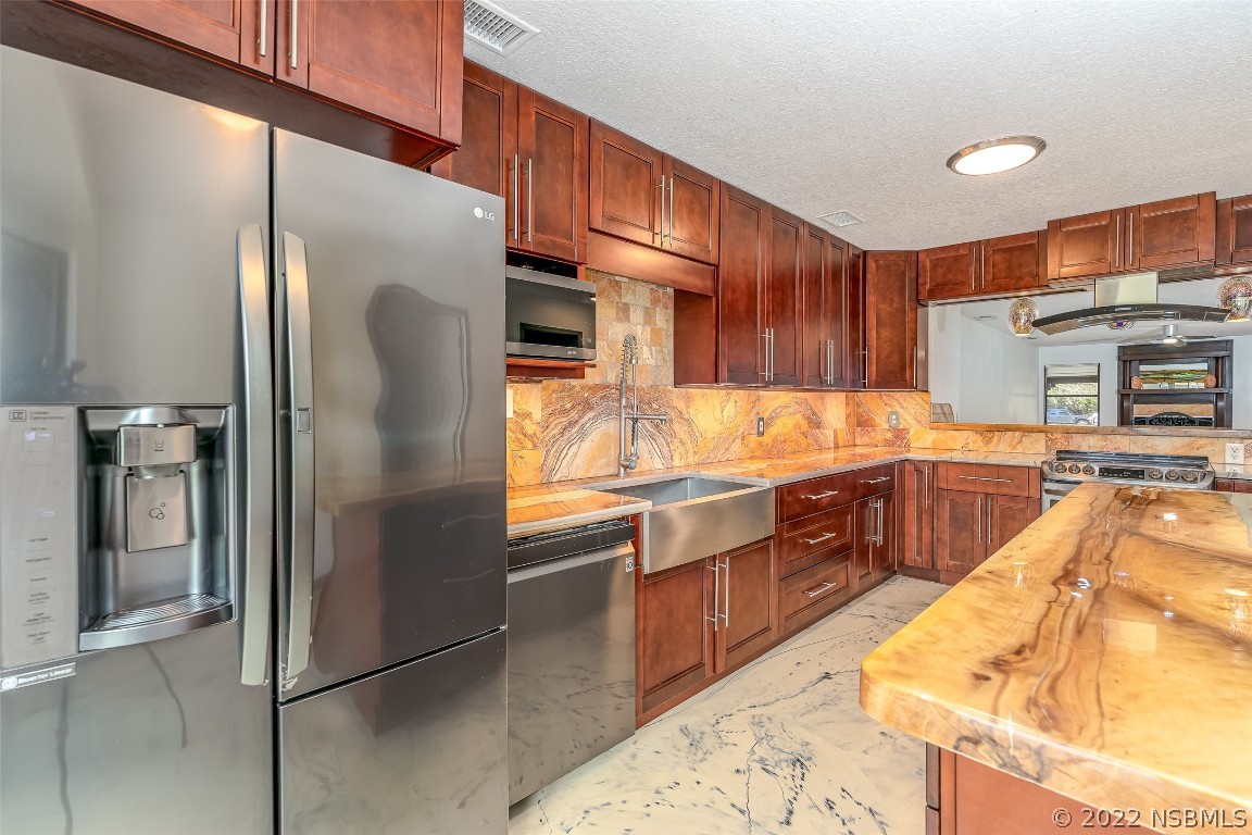 Undisclosed Address Edgewater, FL 32141 - Photo 11 of 37 a kitchen with stainless steel appliances granite countertop a refrigerator a sink and a stove