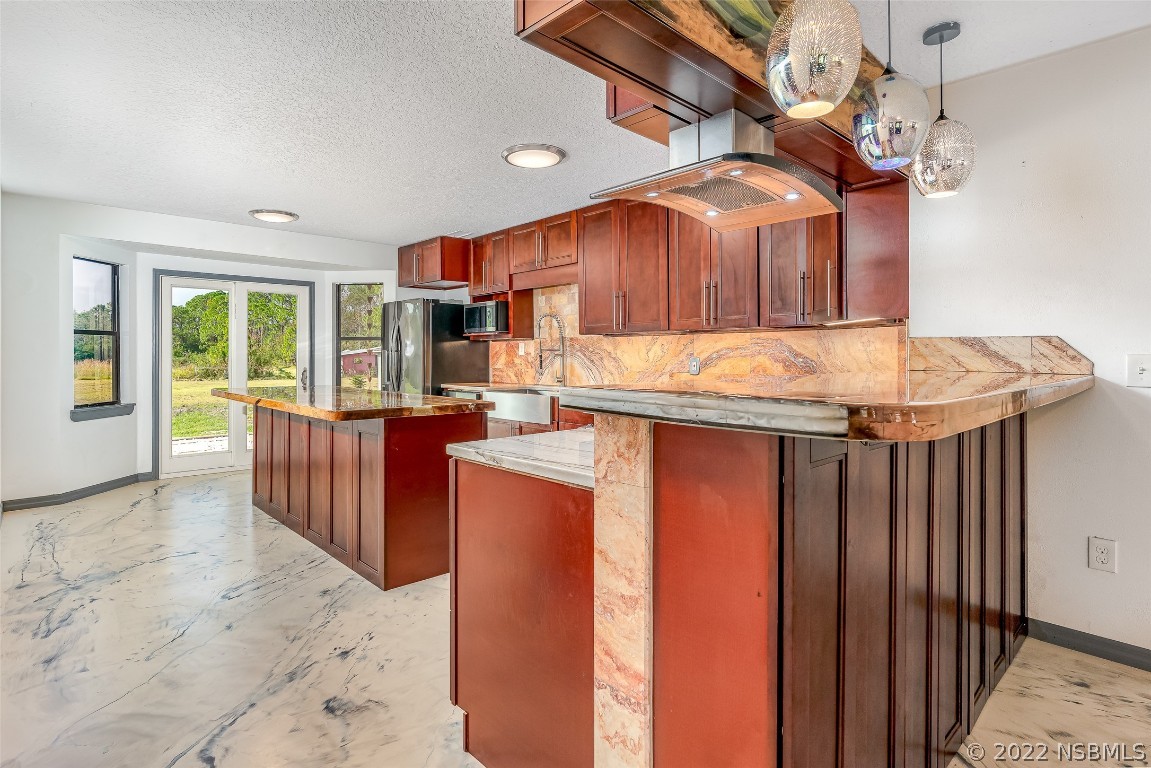 Undisclosed Address Edgewater, FL 32141 - Photo 13 of 37 a kitchen with stainless steel appliances kitchen island granite countertop a table chairs in it and wooden floor