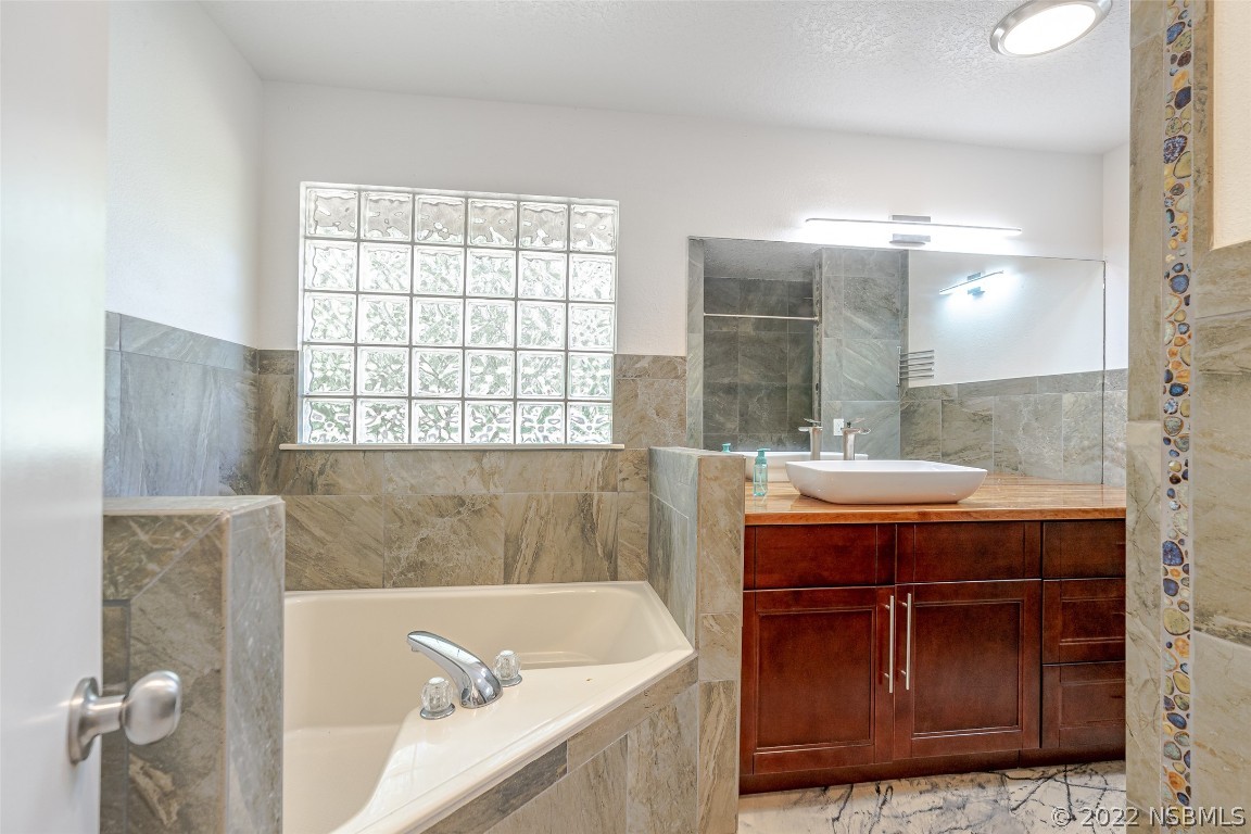 Undisclosed Address Edgewater, FL 32141 - Photo 18 of 37 a bathroom with a tub sink and mirror