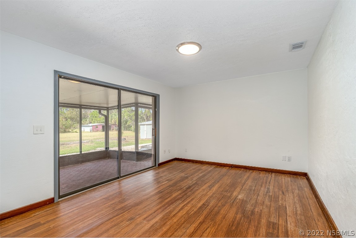 Undisclosed Address Edgewater, FL 32141 - Photo 23 of 37 an empty room with wooden floor and windows