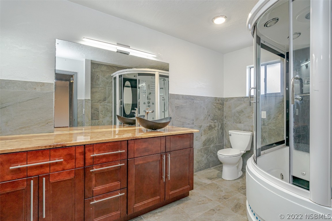 Undisclosed Address Edgewater, FL 32141 - Photo 27 of 37 a spacious bathroom with a toilet sink and mirror