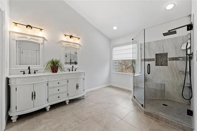 a bathroom with a double vanity sink mirror and shower