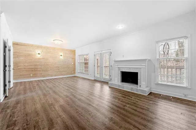a view of empty room with wooden floor and fireplace