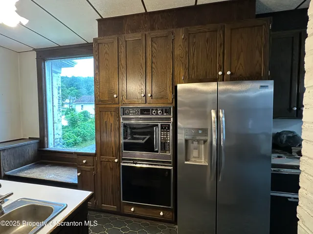 a kitchen with granite countertop a refrigerator stove and cabinets
