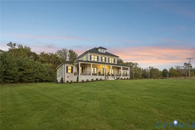 a view of a big house with a big yard and large trees