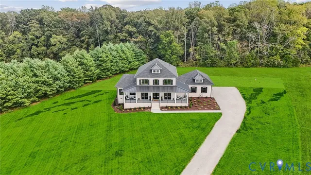 a view of a house with a big yard and large trees