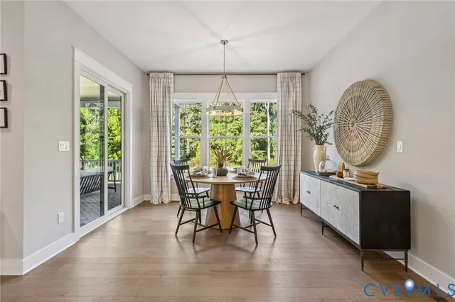 a dining room with furniture a chandelier and wooden floor