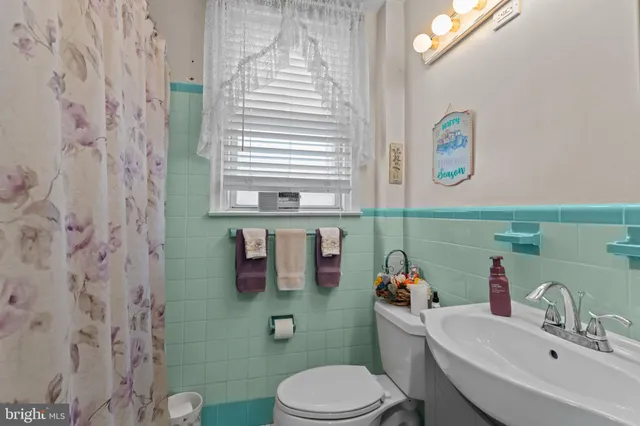 an empty room with a chandelier fan and windows