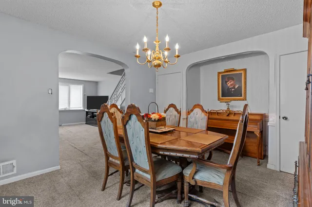 a kitchen with stainless steel appliances granite countertop a refrigerator and a dining table