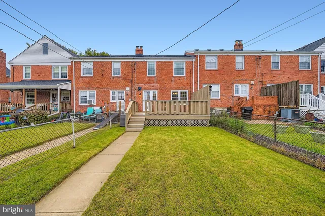 a view of house with a yard and table and chairs under an umbrella