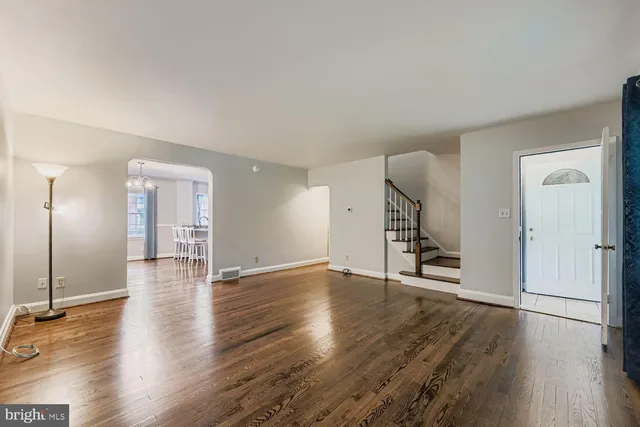 an empty room with wooden floor and entryway
