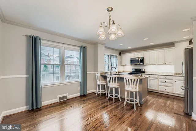 a view of a dining room with furniture a kitchen and chandelier