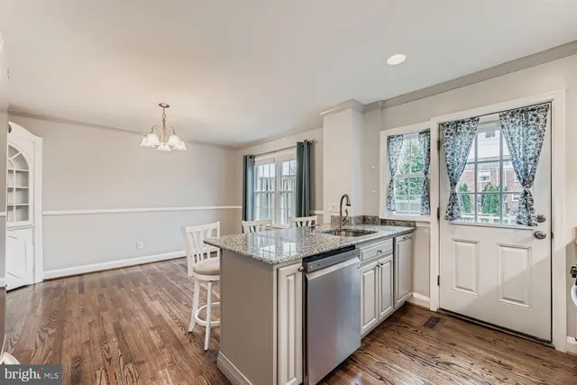 a kitchen with granite countertop cabinets stainless steel appliances a sink and a large window