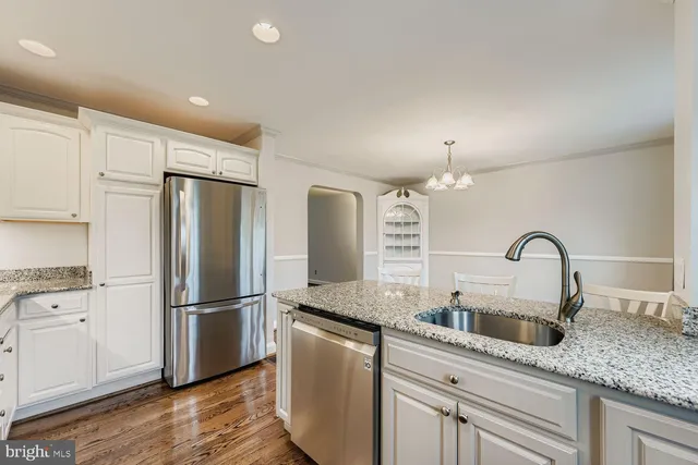 a kitchen with kitchen island granite countertop a sink cabinets and stainless steel appliances