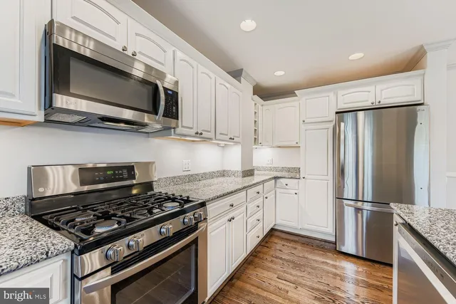 a kitchen with stainless steel appliances granite countertop a stove microwave sink and refrigerator