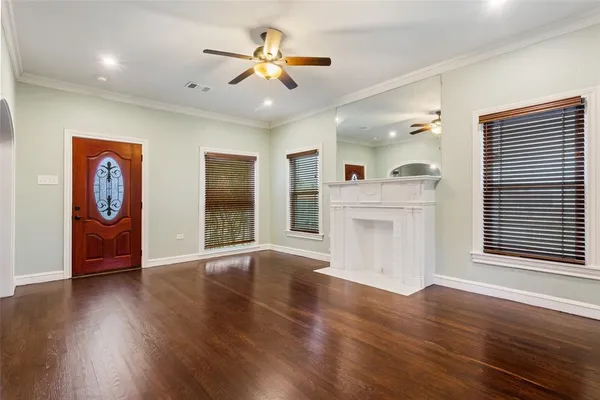 a view of an empty room with window and wooden floor