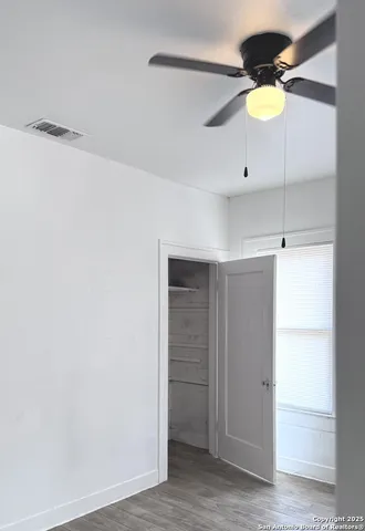 a bathroom with a light fixture and a ceiling fan