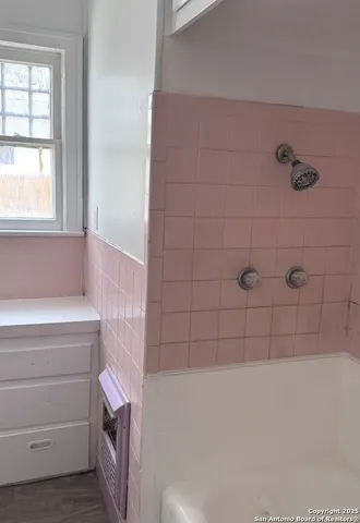 a bathroom with a bathtub and window