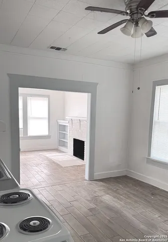 a view of an empty room with a window and fireplace