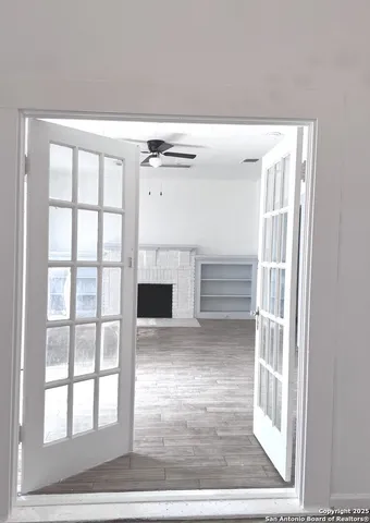 a room with a fireplace and a ceiling fan